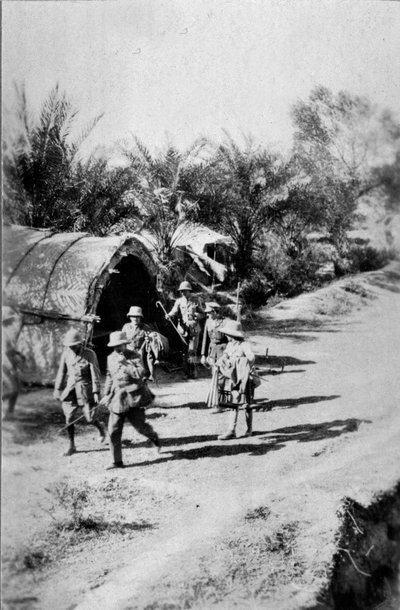 Officers Walking Past a Reed Hut, 1917 by English Photographer